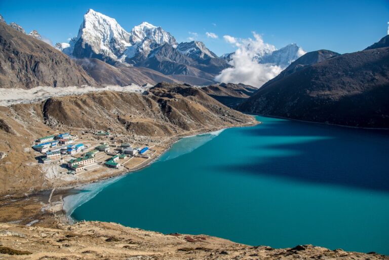 small-town-near-blue-body-water-surrounded-by-beautiful-mountains_181624-4768